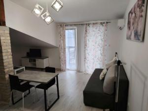 ein Wohnzimmer mit Sofa und Tisch in der Unterkunft Odličan smeštaj blizu centra in Novi Sad