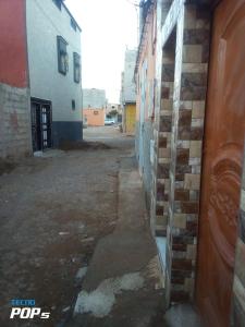 an empty alley with a brick wall and a building at شقة مريحة بجانب مطار المسيرة اكادير in Ikhorbane