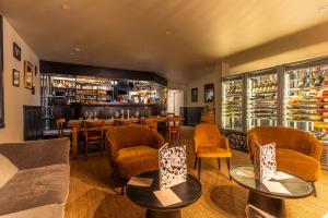 レ・ルースにあるHôtel Restaurant La Fermeのテーブルと椅子とバーのあるレストラン