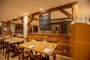 レ・ルースにあるHôtel Restaurant La Fermeの木製のテーブルと椅子、チョークボードのあるレストラン +19枚の写真