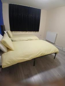 two beds in a room with a window at The Stadium Rooms Elegant and Comfy Stay in London