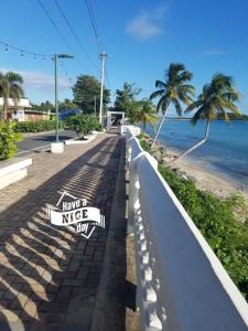 ein Schild auf einem Bürgersteig neben dem Strand in der Unterkunft Trade Winds Restaurant & Guest House in Vieques