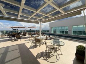 a patio with tables and chairs on a building at Saint Moritz Hotel - ALM Hospedagens - Flat Particular in Brasilia