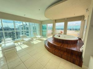 a large bathroom with a tub in a room with windows at Saint Moritz Hotel - ALM Hospedagens - Flat Particular in Brasilia