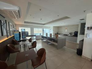 a large kitchen with tables and chairs in a room at Saint Moritz Hotel - ALM Hospedagens - Flat Particular in Brasilia +18 photos