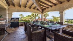 eine Außenterrasse mit einem Tisch, Stühlen und einem Grill in der Unterkunft SainteMaxime PremiumVilla PrivatePool in Sainte-Maxime