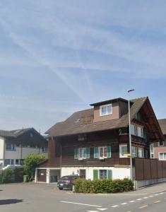 a building on the side of a street with a car at Lakeberry Apartment in Freienbach