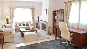 a living room with a desk and a living room with a couch at Casa Pinsa - Großzügiges mediterran-stilvolles Ferienhaus mit eigenem Pool in Puig de Ros in Llucmajor