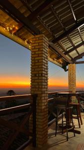 a patio with a table and a view of the sunset at Belaninha in Guaramiranga