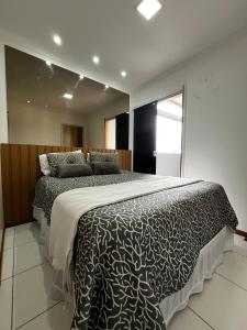 a bedroom with a bed with a black and white comforter at Apart 3qtrs á 1200m da praia de Itapuã in Vila Velha