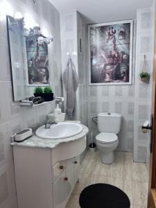 Casa Blanca - apartamento en Gandia في غانديا: حمام أبيض مع حوض ومرحاض +49 صورة