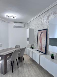a dining room with a table and chairs and a painting at Casa Blanca - apartamento en Gandia in Gandía