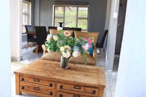 a vase of flowers sitting on a coffee table at Maison Royale Lodge in Nongoma