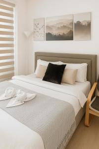 a bedroom with a large bed with two towels on it at Tala Haven at Azure North Studio with Mt Arayat View in San Fernando