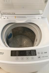 a white washing machine with its door open at Tala Haven at Azure North Studio with Mt Arayat View in San Fernando +14 photos