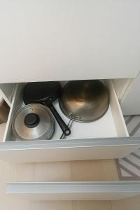 two pots and pans sitting on a shelf in a drawer at Tala Haven at Azure North Studio with Mt Arayat View in San Fernando