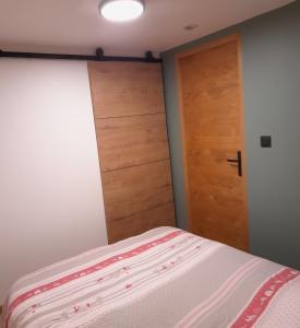 a bedroom with a bed and a wooden door at Chez Mat in Lans-en-Vercors