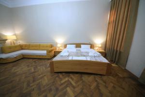 Un dormitorio con una cama grande y un sofá. en Gallery inn, en Kutaisi