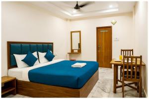 - une chambre avec un lit bleu, un bureau et une chaise dans l'établissement Hotel RGH Palace Inn NEAR VISHWANATH TEMPLE # Fully Air Conditioning Luxuary Hotel, à Varanasi