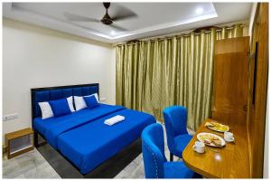 - une chambre avec un lit bleu et une table dans l'établissement Hotel RGH Palace Inn NEAR VISHWANATH TEMPLE # Fully Air Conditioning Luxuary Hotel, à Varanasi