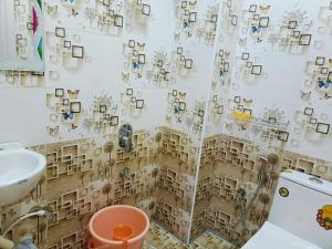 ein Bad mit einem Duschvorhang mit Bildern darauf in der Unterkunft Pure Vegeterian 2BHK Private Guest House - Air Cnditioned - WiFi - Full Kitchen - No Alcohol Zone - Hilltop Heaven in Yelagiri + 12 Fotos