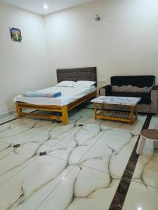 ein Schlafzimmer mit einem Bett und einer Couch in der Unterkunft Pure Vegeterian 2BHK Private Guest House - Air Cnditioned - WiFi - Full Kitchen - No Alcohol Zone - Hilltop Heaven in Yelagiri