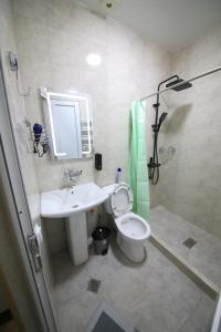 Un baño con lavabo, inodoro y ducha. en Gallery inn, en Kutaisi