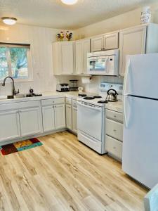 奥克赫斯特Ely Farm House - Near Yosemite National Park的铺有木地板的厨房配有白色家电