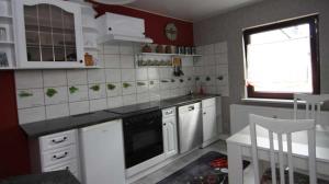 a small kitchen with white cabinets and a window at Ferienwohnung Kresse 
