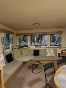 ein Wohnzimmer mit einer Couch und einigen Fenstern in der Unterkunft Seaton Sands 71 Aberlady in Port Seton