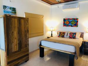 une chambre avec un lit et une armoire en bois dans l'établissement Palm Life Belize, à Caye Caulker