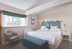 um quarto com uma cama grande e uma cadeira em The Globe em Exeter