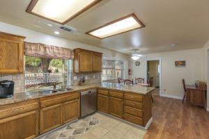 eine große Küche mit Holzschränken und einem Waschbecken in der Unterkunft Sullivan House & SPA Near Yosemite, 8 Min to Town in Mariposa