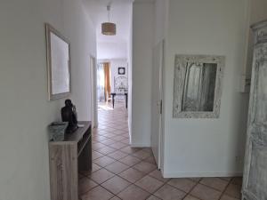 クレにあるLamaisonxvの白い壁の廊下と鏡が備わる客室です。 +12枚の写真