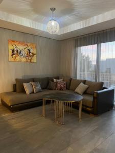 ein Wohnzimmer mit Sofa und Tisch in der Unterkunft Luxury 2BR Apartment Taghazout Bay 1 min walk to beach in Tamraght Ouzdar