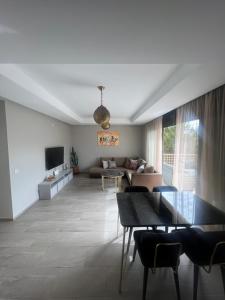 ein Wohnzimmer mit Tisch und Couch in der Unterkunft Luxury 2BR Apartment Taghazout Bay 1 min walk to beach in Tamraght Ouzdar