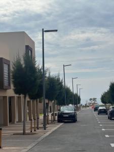 ein Auto parkt auf einem Parkplatz neben einer Straße in der Unterkunft Luxury 2BR Apartment Taghazout Bay 1 min walk to beach in Tamraght Ouzdar