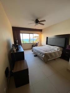 une chambre avec un lit et un ventilateur de plafond dans l'établissement Departamento frente al mar con alberca, à Telchac Puerto 9 autres photos
