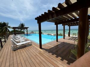 une terrasse avec des chaises longues et une piscine dans l'établissement Departamento frente al mar con alberca, à Telchac Puerto