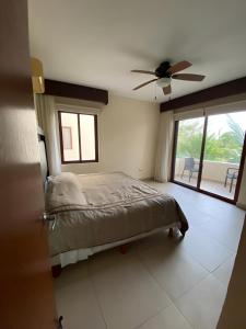 une chambre avec un lit et un ventilateur de plafond dans l'établissement Departamento frente al mar con alberca, à Telchac Puerto