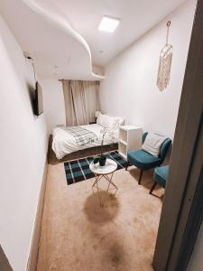 a bedroom with a bed and a table and a chair at Charming Studio in the Heart of Ealing Broadway in Ealing