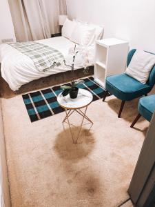 a bedroom with a bed and a table and a chair at Charming Studio in the Heart of Ealing Broadway in Ealing +15 photos