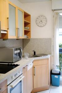 eine Küche mit Spüle und einer Uhr an der Wand in der Unterkunft Grand famille appartement proche Disneyland max 9 personnes in La Celle-sous-Gouzon + 18 Fotos
