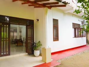 an open door of a house with a patio at Thisaru Homestay in Weligama