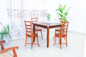 a wooden table and chairs in a room with plants at Thisaru Homestay in Weligama