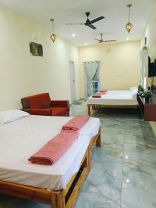 ein Schlafzimmer mit zwei Betten und einer Decke in der Unterkunft Pure Vegeterian 1BHK Private Guest House - Air Cnditioned - WiFi - Full Kitchen - No Alcohol Zone - Hilltop Heaven in Yelagiri