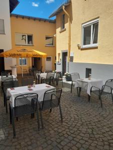 a group of tables and chairs in front of a building at Pension Zum Adler in Limbach