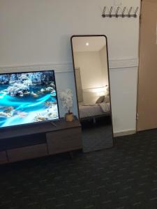 espejo en una habitación con TV y cama en Studio with simple furniture Self check-in Al Khobar - Al Thaqba - 7, en Al Khobar