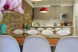 une salle à manger avec des chaises blanches et une table dans l'établissement Albergue de Pamplona-Iruñako, à Pampelune