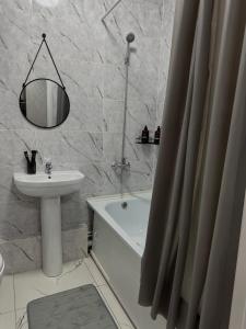 ein Badezimmer mit Waschbecken, Toilette und Badewanne in der Unterkunft Однокомнатная квартира 463 in Qostanai